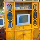 طاولة تلفزيون قديمه بالاغراض الي فيها