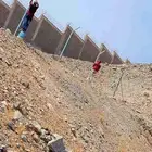 بنا الحجر الطبيعي وتركيب اسياج الشبوك وزراعة النخيل
