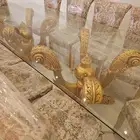 طاولة طعام فخمة زجاجية مع كراسي ذهبية