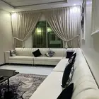 كنب جديد على شكل حرف L مع طاوله وأربع طاولات ضيافة