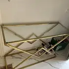 طاولة هيكل ذهبي وفوقها قزاز