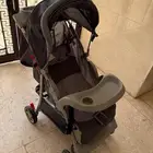 كرسي أطفال متحرك فيه ثلاثه حاملات أكواب