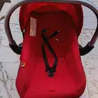 Red car seat for children with a handle to carry it