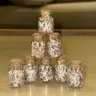 قوارير زجاجية صغيرة معبأة بعملات مقطعة