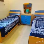غرفه سريرين و خزانه و طاولتين و يسحابه ملابس الغرفه في