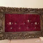 علاقة ملابس فنتج بإطار ذهبي وقطيفة عنابية