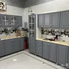 مطبخ صغير و انبوبة غاز و موكيت و مساند