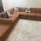 كنب على شكل حرف L مع زولية الواضحه بالصورة