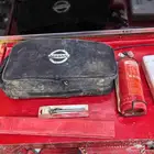 شنطة نيسان تحتوي على طفاية وصيدلية ومثلث وعيار هواء