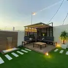تنسيق حدائق عشب صناعي مظلات جلسات مرتفعة شلالات