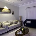 غرفة جلوس (صالون) مع طاولاتها واللوح والاكسسوارات